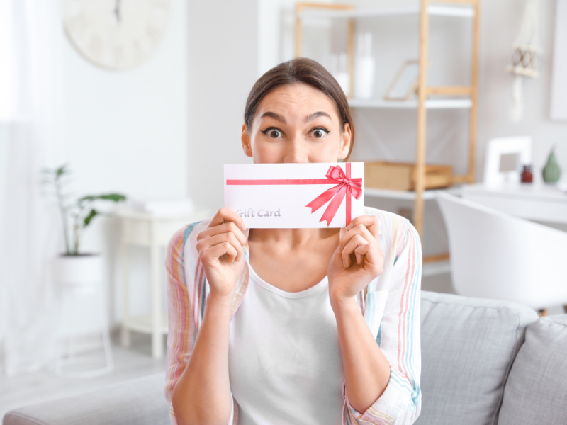 gift giving etiquette - women holding up gift card in a decorative envelope
